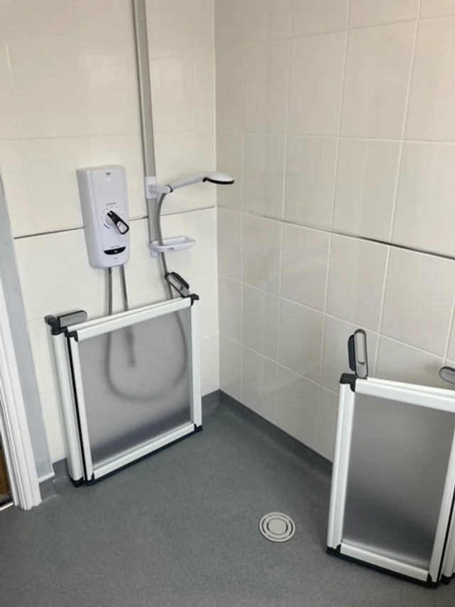 Wet room shower with fold-away screens